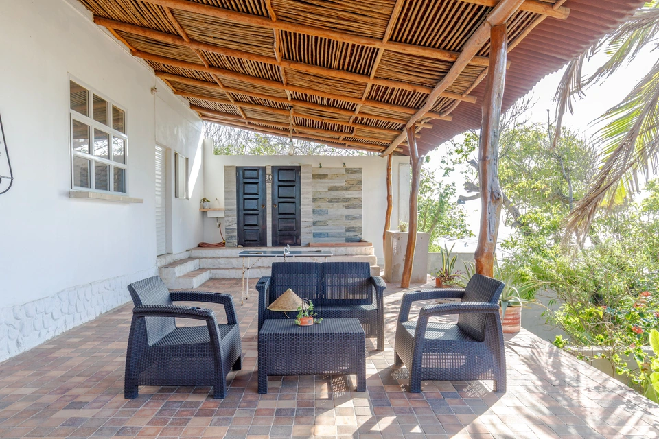 Covered patio seating area surrounded by tropical greenery