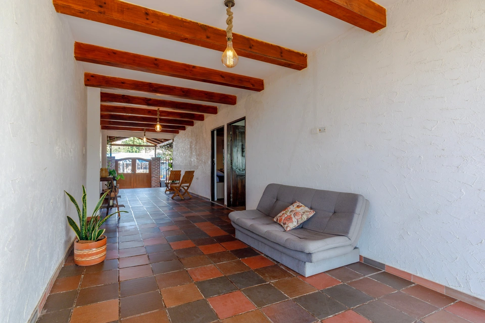 Long covered patio corridor with exposed beams and seating