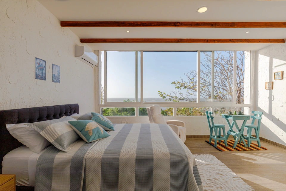 Room 3 bed beside ocean-facing windows